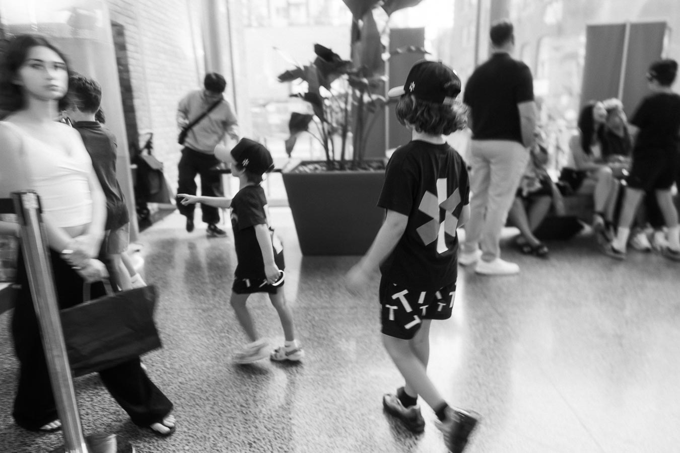 Children in Toronto Prep School shirts walk and interact in Ricarda’s Atrium, with families and guests in the background at the school launch event.