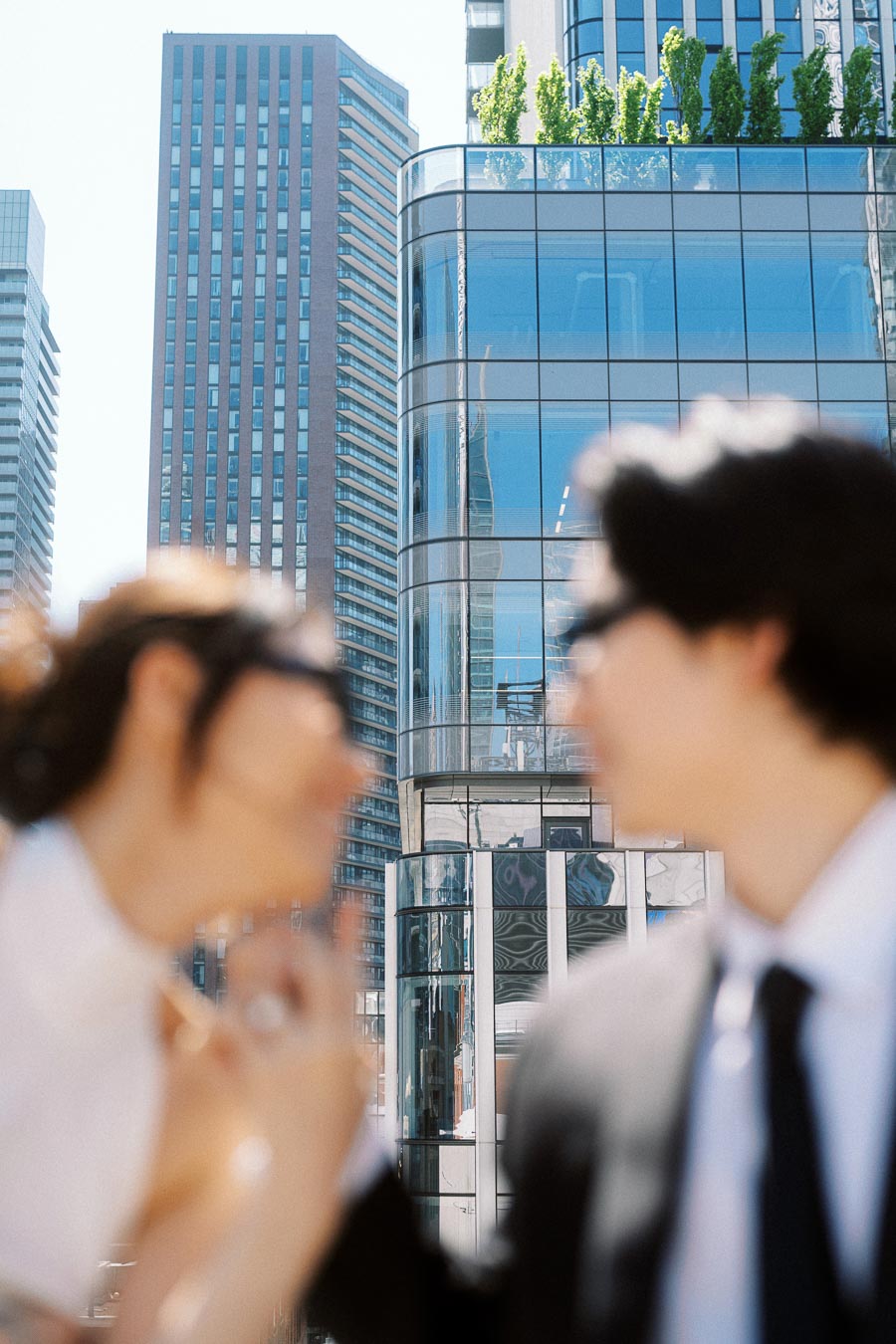 Out-of-focus couple in formal outfits with modern Toronto skyscrapers and glass buildings in the background.