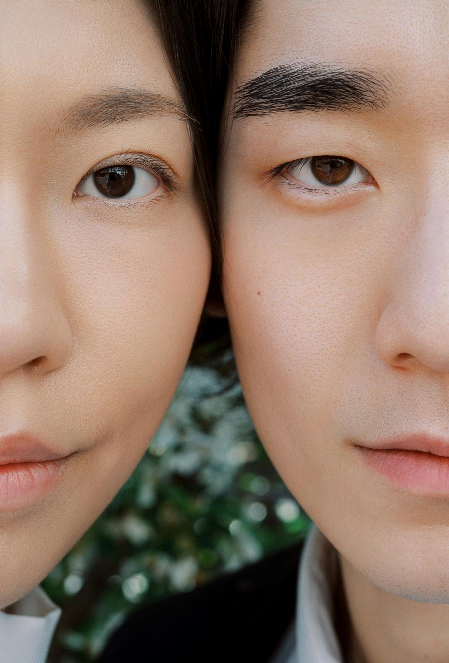 Extreme close-up of two people, Jun and Alex, with their faces side by side, showing soft expressions and smooth skin.