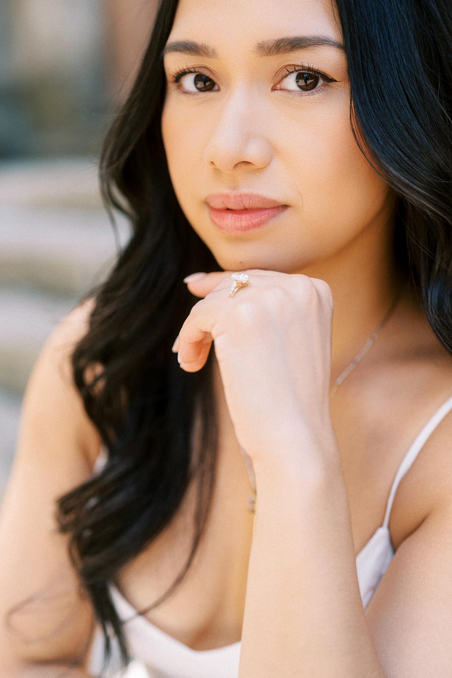 Close-up of Cassie resting her chin on her hand, showing her engagement ring during an engagement session in downtown Toronto.