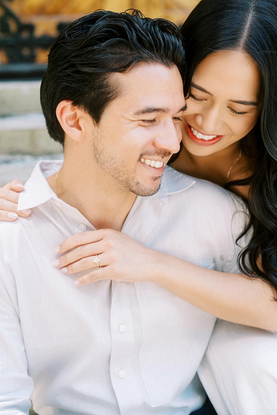 Cassie and Gabriel smiling closely together, with Cassie’s arm around Gabriel and her engagement ring visible, during their engagement session in Toronto.