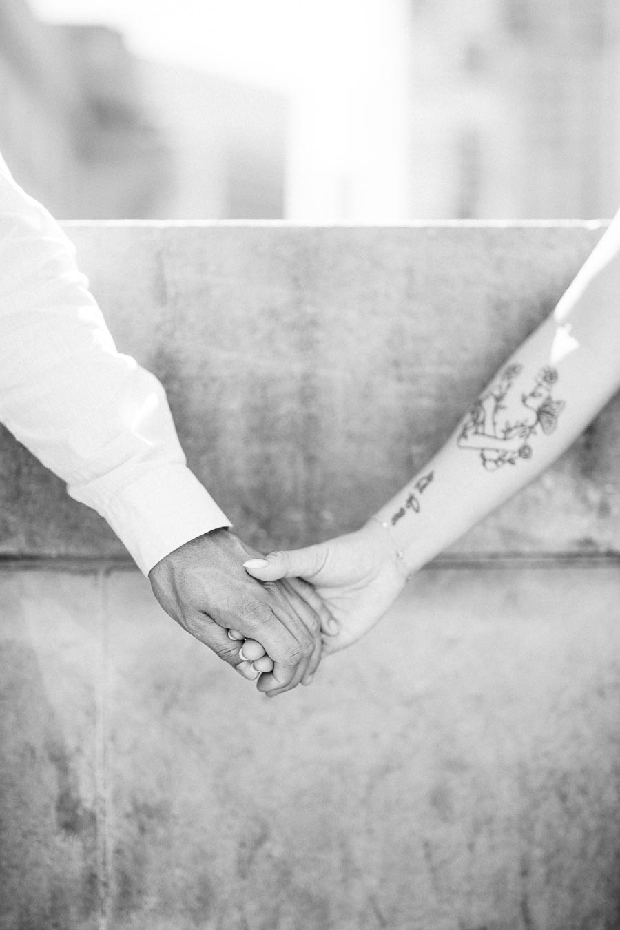 Close-up of Cassie and Gabriel holding hands in black and white during their engagement session in downtown Toronto.