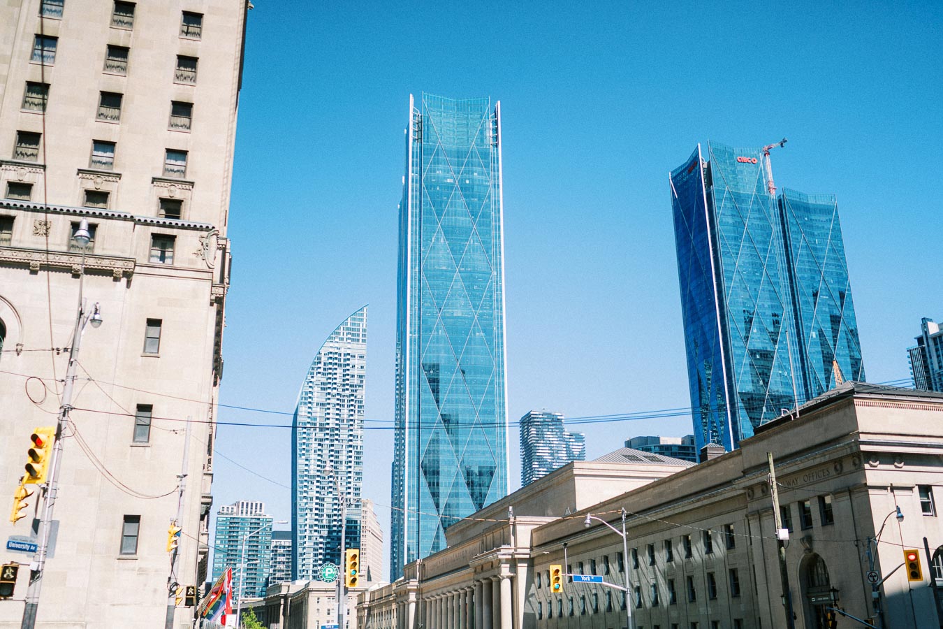 Downtown Toronto cityscape with modern glass skyscrapers and historic buildings on a sunny day.