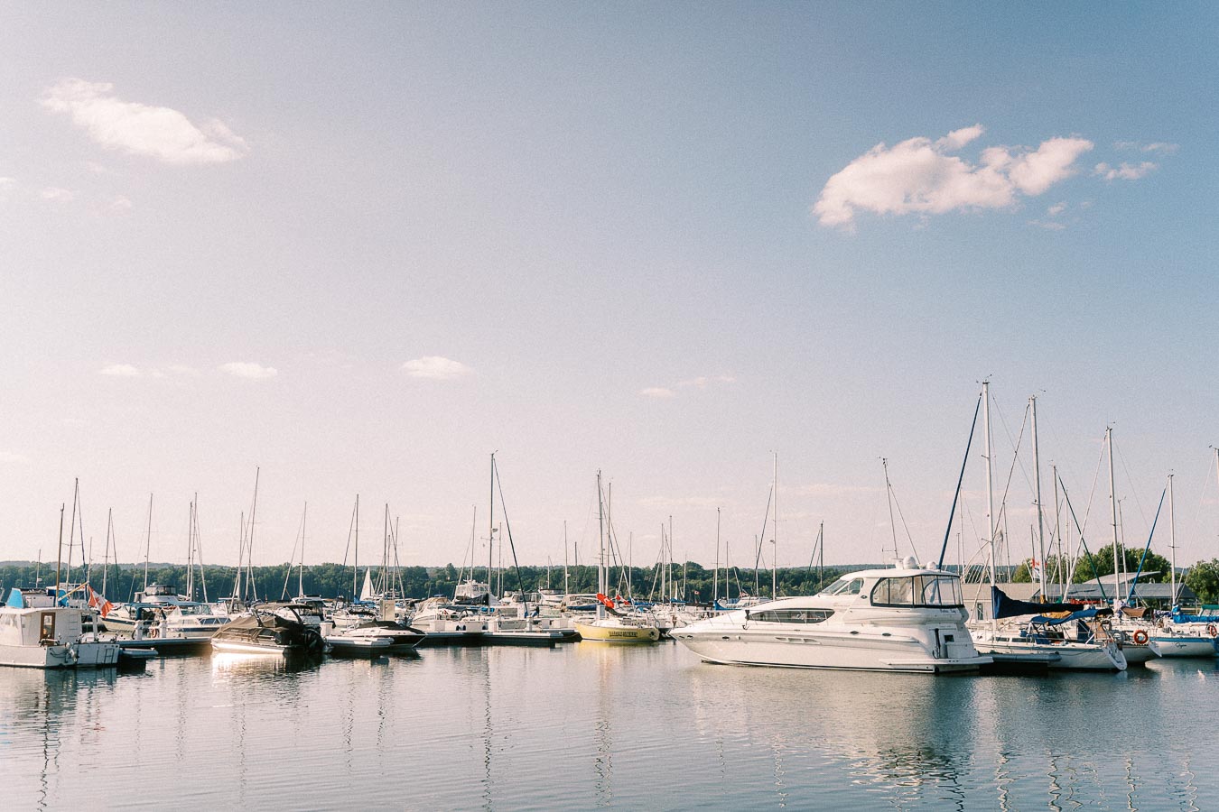 Sailboats and yachts docked at Royal Hamilton Yacht Club marina on calm Lake Ontario water.