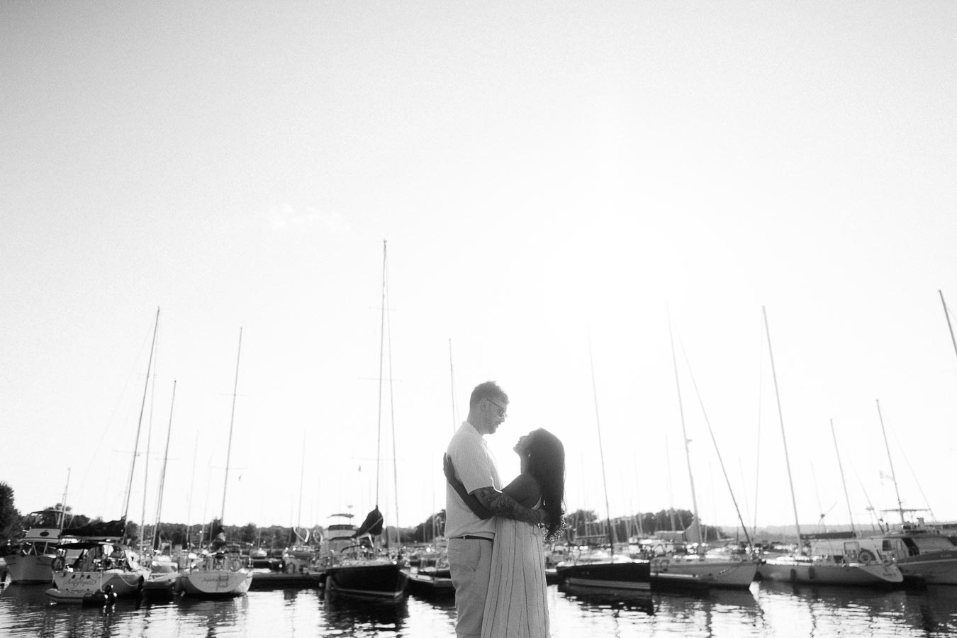 Amber and Devin embrace in silhouette at a sailboat marina in Hamilton, Ontario.