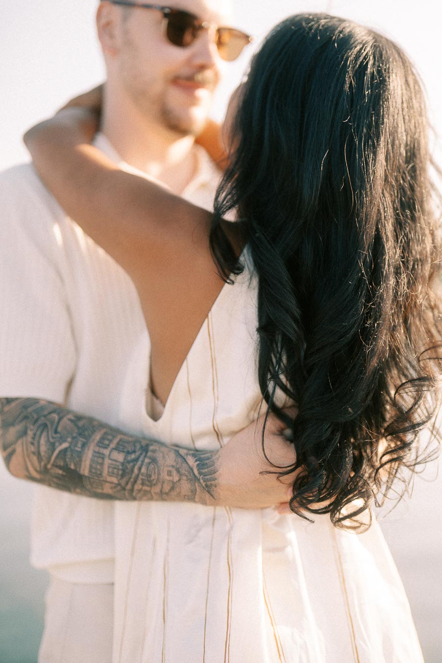 Close-up of Amber and Devin embracing in warm golden hour light during their engagement session.