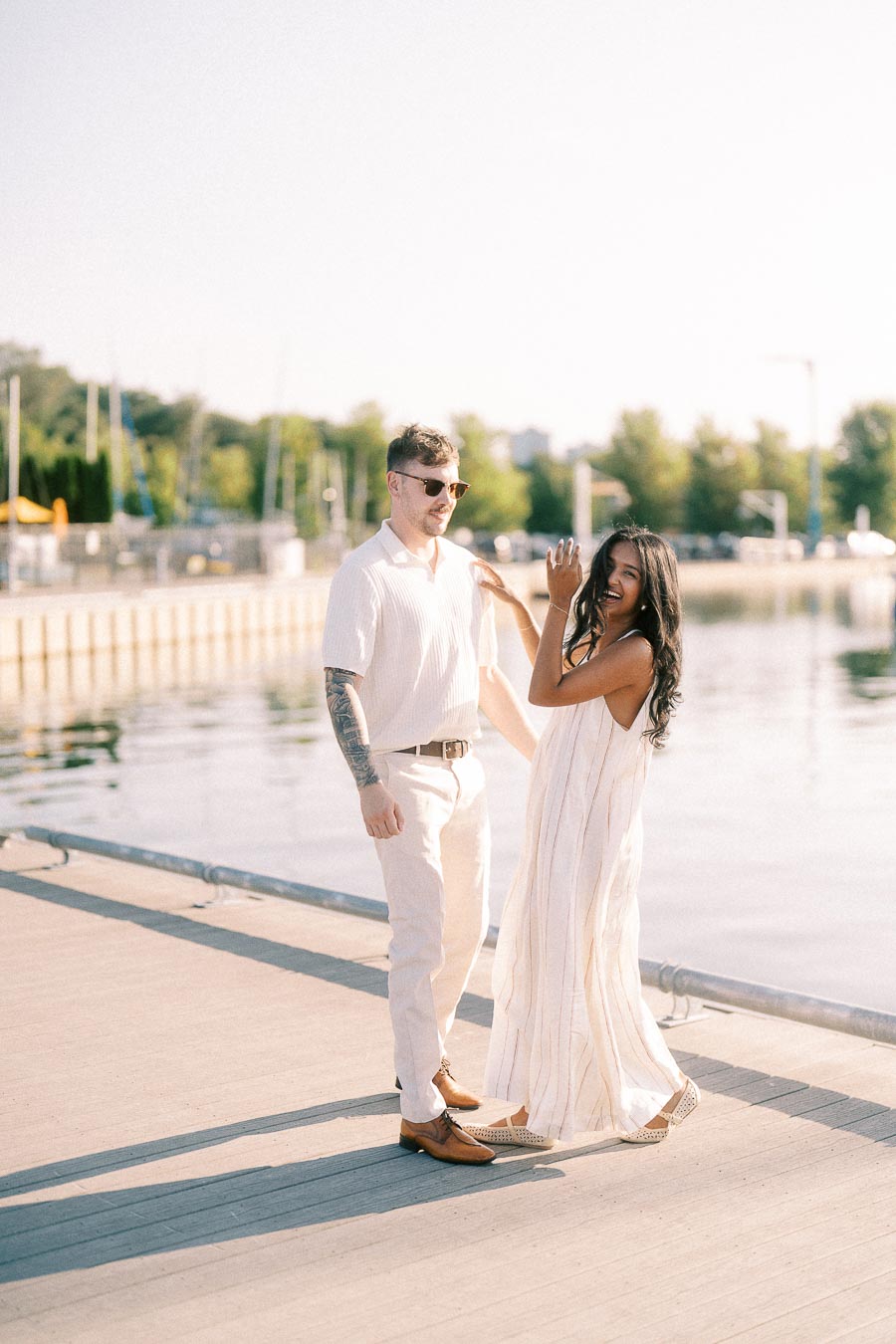 Amber and Devin standing together on a marina dock during their Hamilton engagement session.