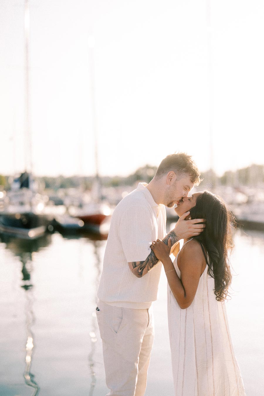 Amber and Devin share a kiss beside sailboats at the Royal Hamilton Yacht Club marina.