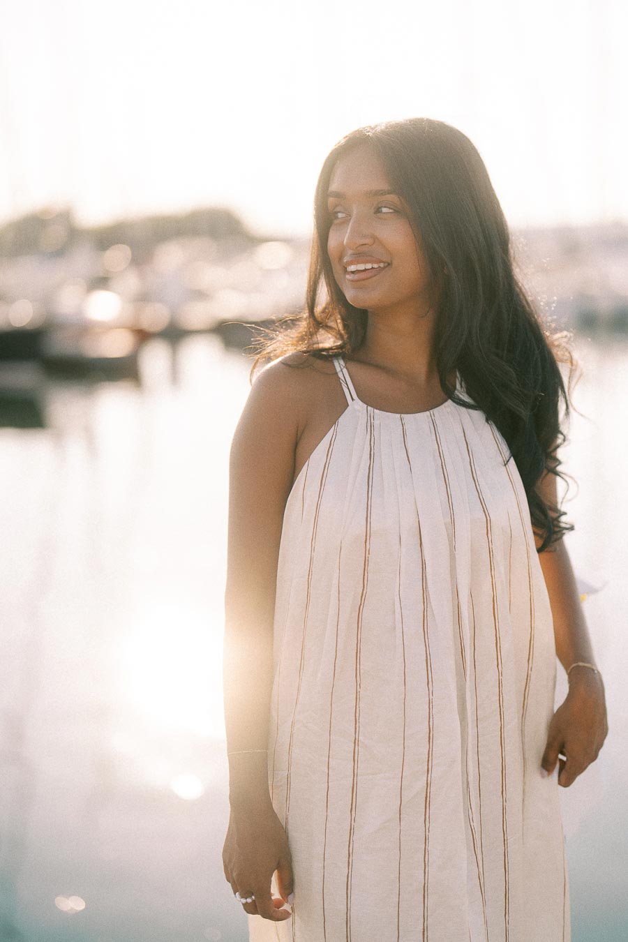 Amber smiling in a white dress beside the sunlit marina at Royal Hamilton Yacht Club.