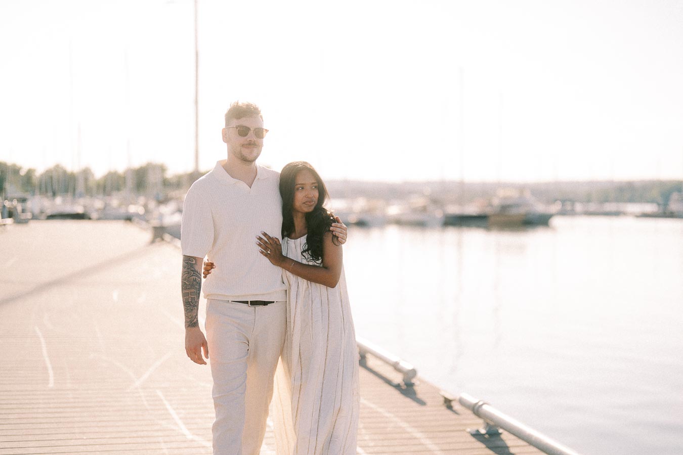 Amber and Devin embrace on a marina dock at golden hour in Hamilton, Ontario.