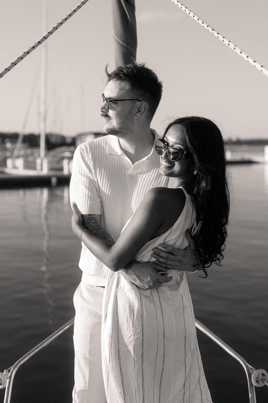 Amber and Devin embrace on a sailboat at the Royal Hamilton Yacht Club marina.