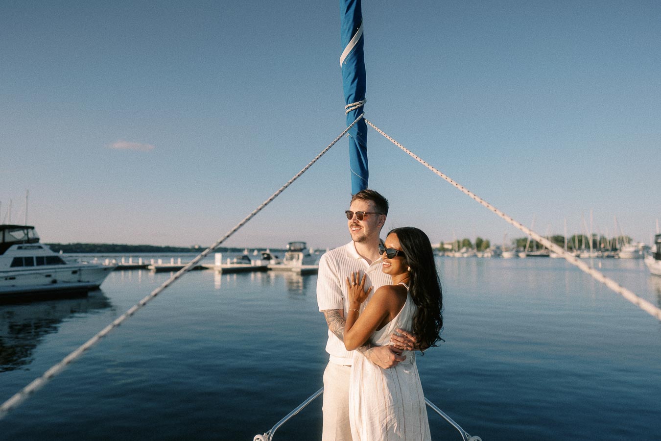 Amber and Devin embracing on a sailboat bow at Royal Hamilton Yacht Club marina.