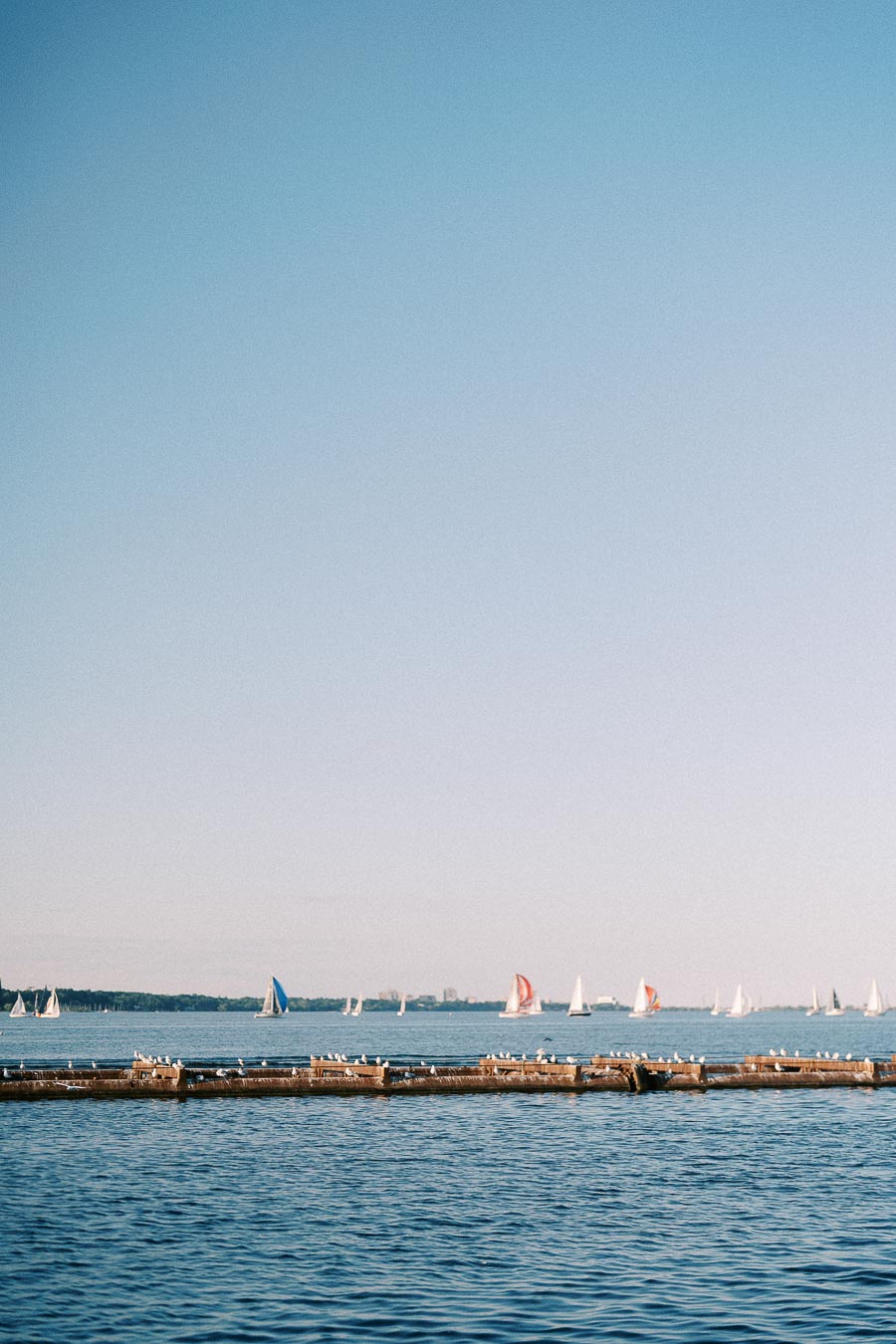 Sailboats on Lake Ontario beyond a dock at Royal Hamilton Yacht Club in Hamilton.