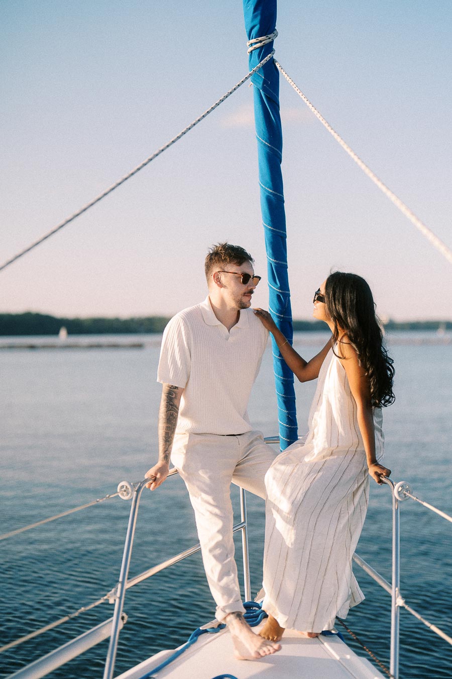 Amber and Devin standing on a sailboat bow during their Hamilton yacht engagement session.
