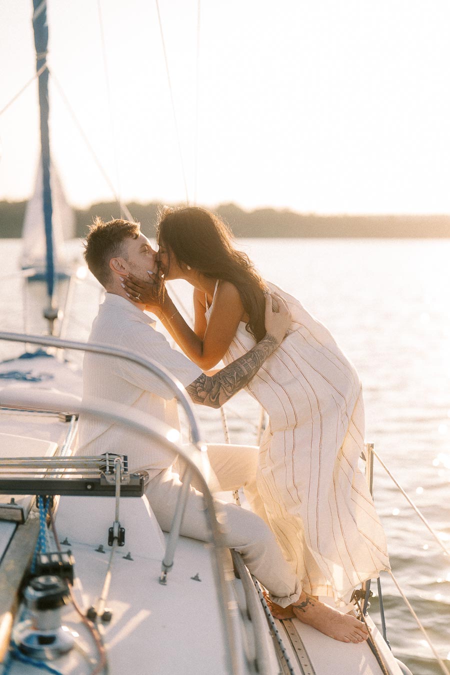 Amber and Devin kissing on a sailboat at sunset during their Hamilton engagement session.