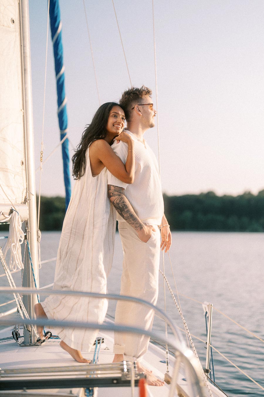 Amber and Devin standing together on a sailboat during their Lake Ontario engagement session.