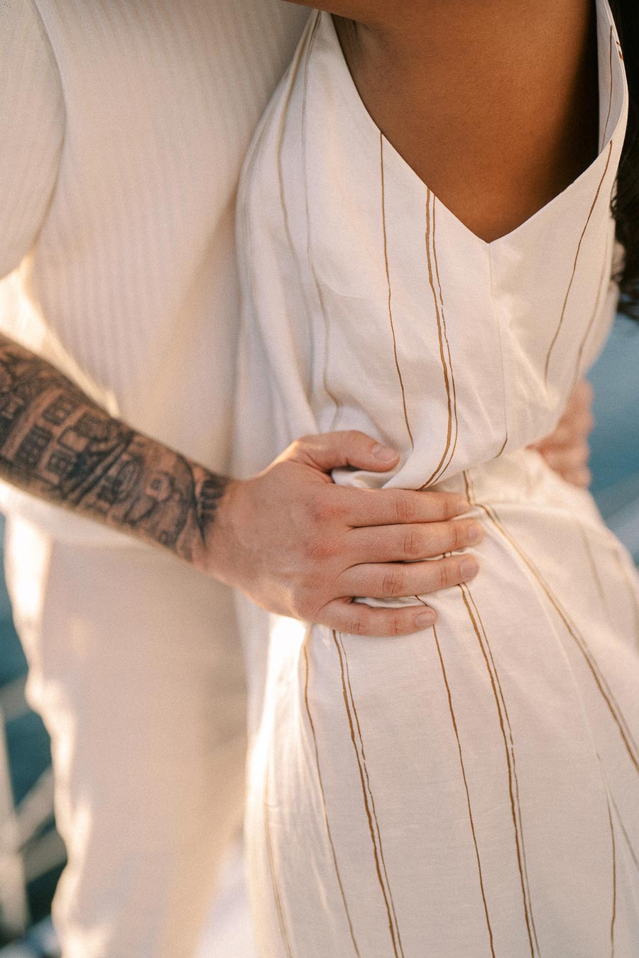 Close-up of Amber and Devin embracing in white outfits during a yacht engagement session.