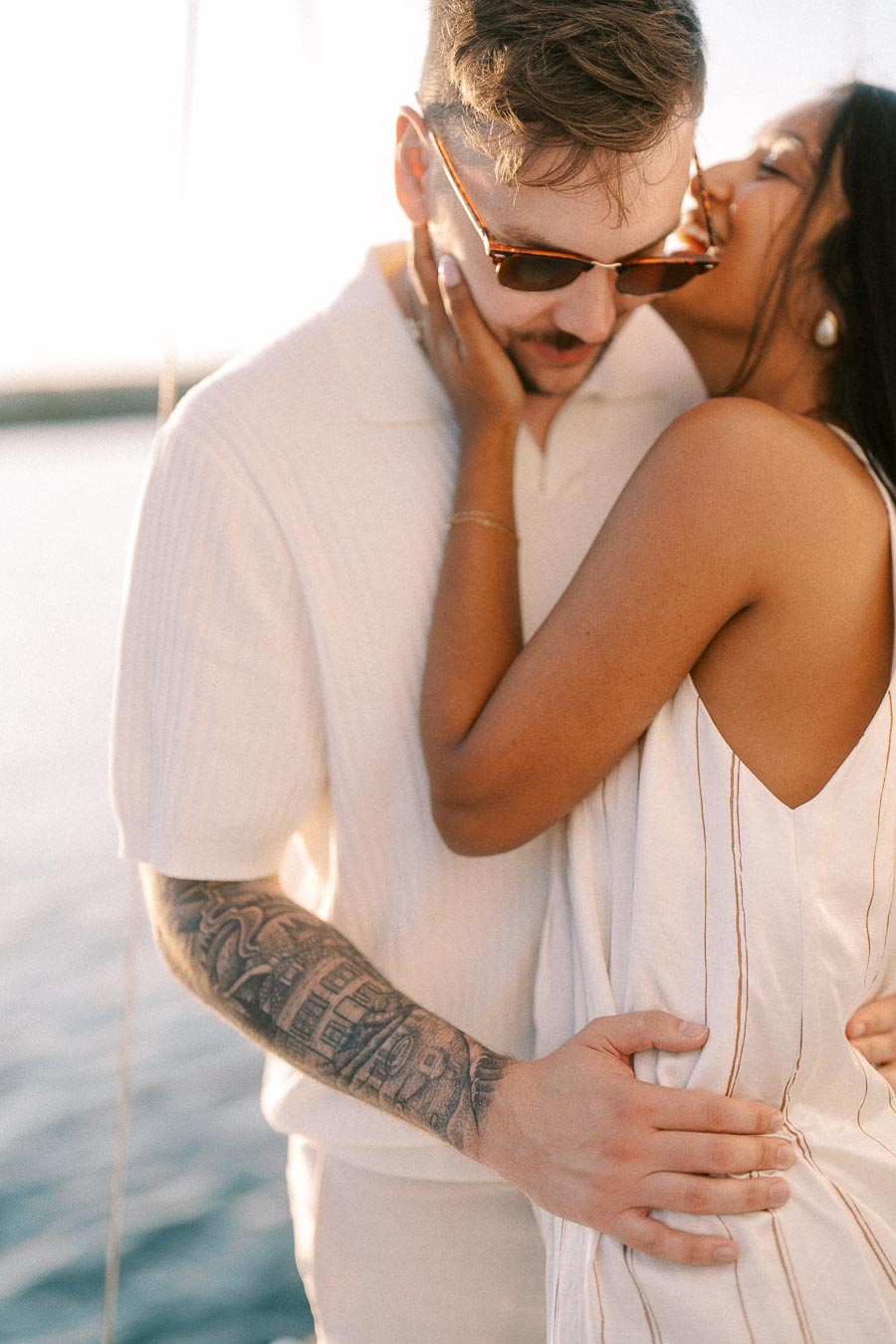 Amber and Devin embrace closely on a sailboat during golden hour in Hamilton, Ontario.
