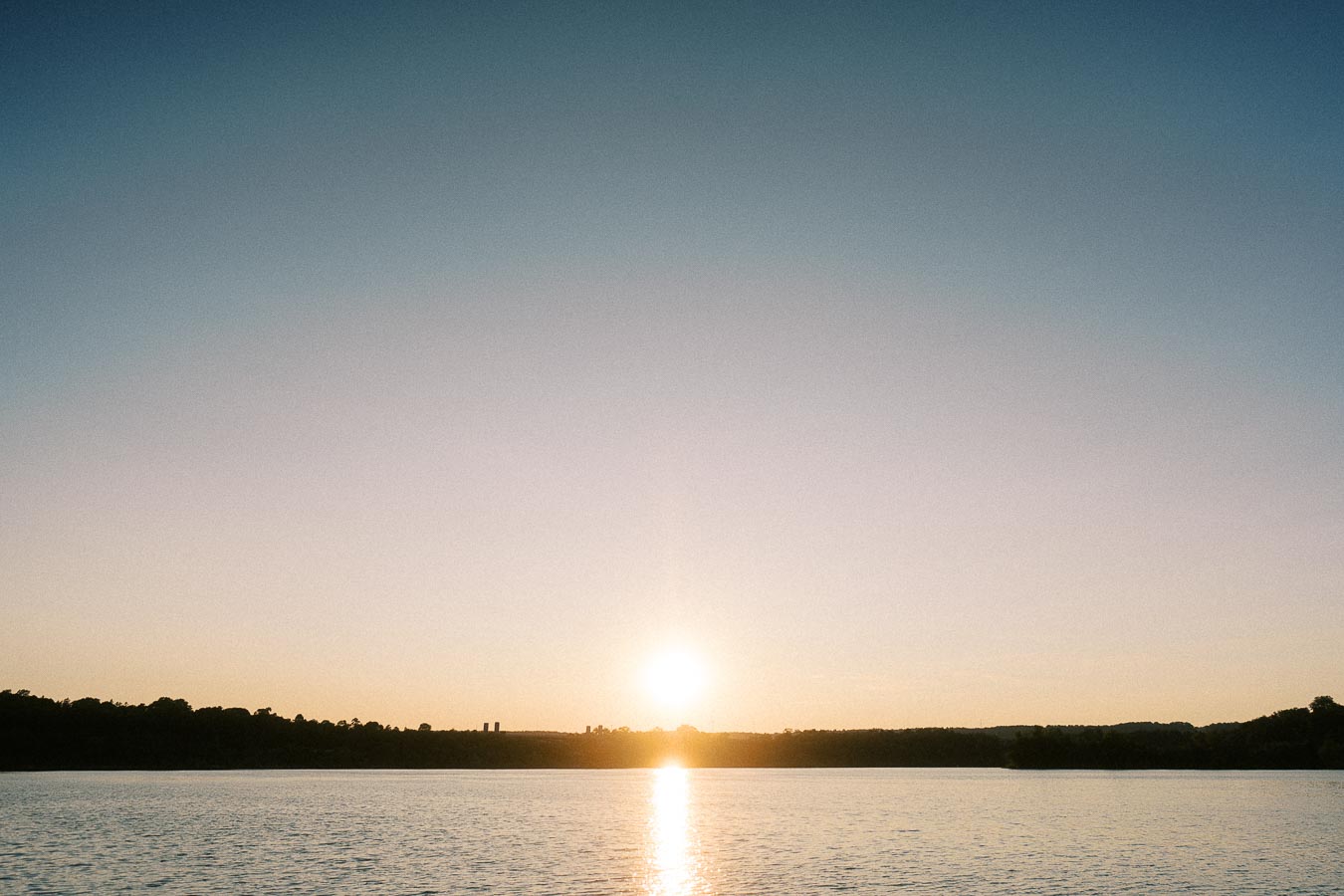 Sunset over calm Lake Ontario water near Hamilton, Ontario during golden hour.