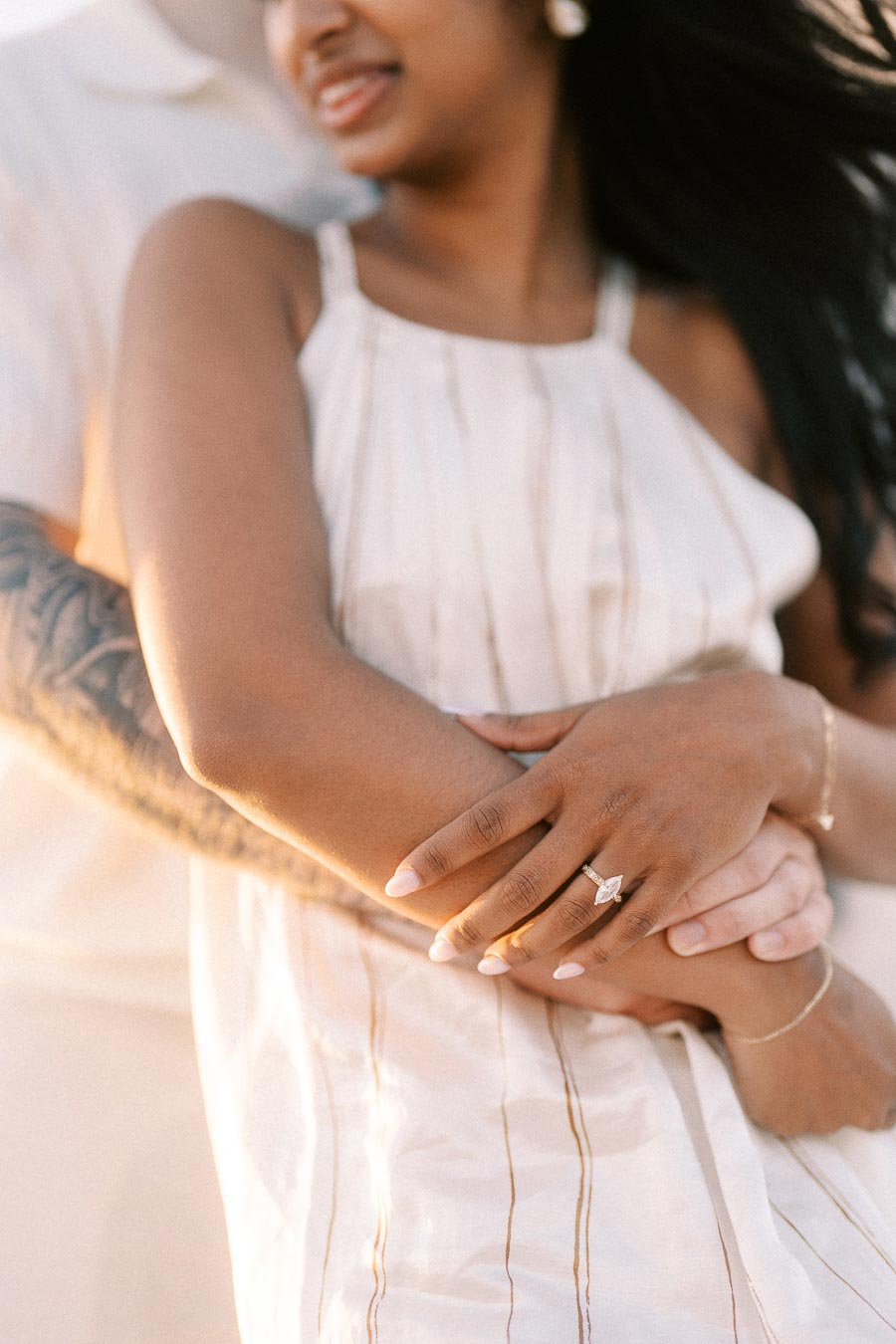 Close-up of Amber’s engagement ring as Devin holds her during golden hour.