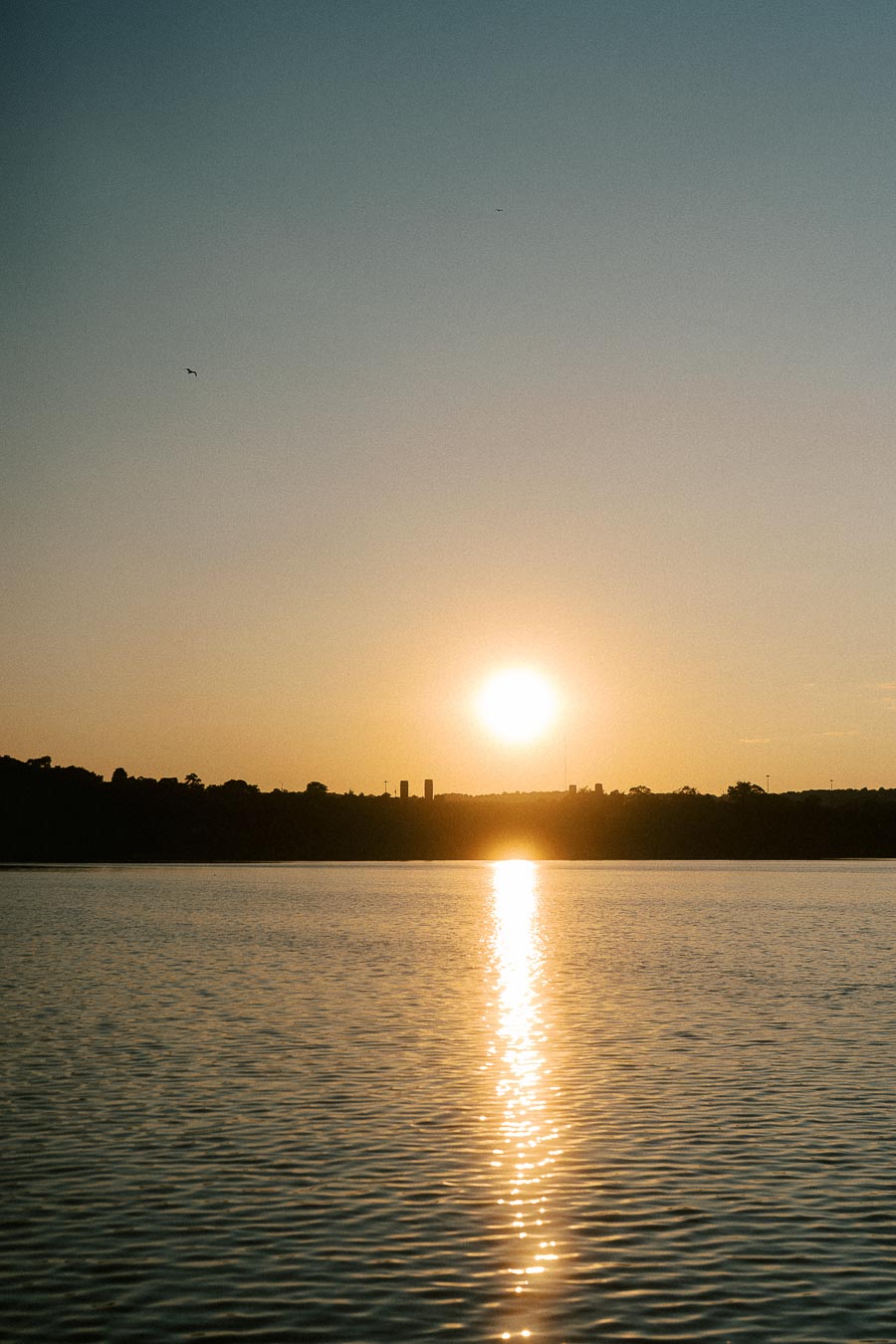 Golden sunset reflecting across Lake Ontario water near Hamilton shoreline.