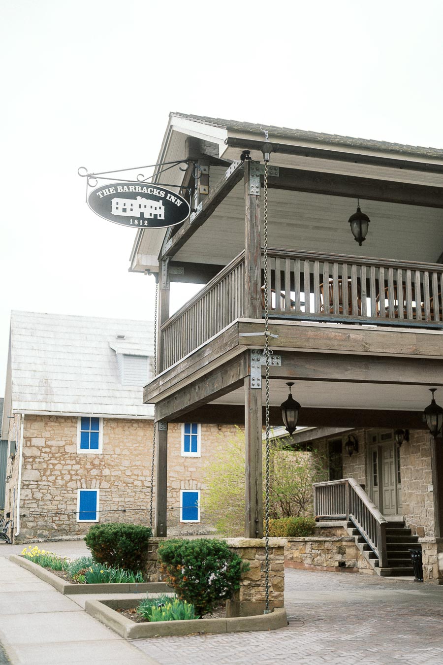 Historic stone inn exterior with porch and The Barracks Inn sign