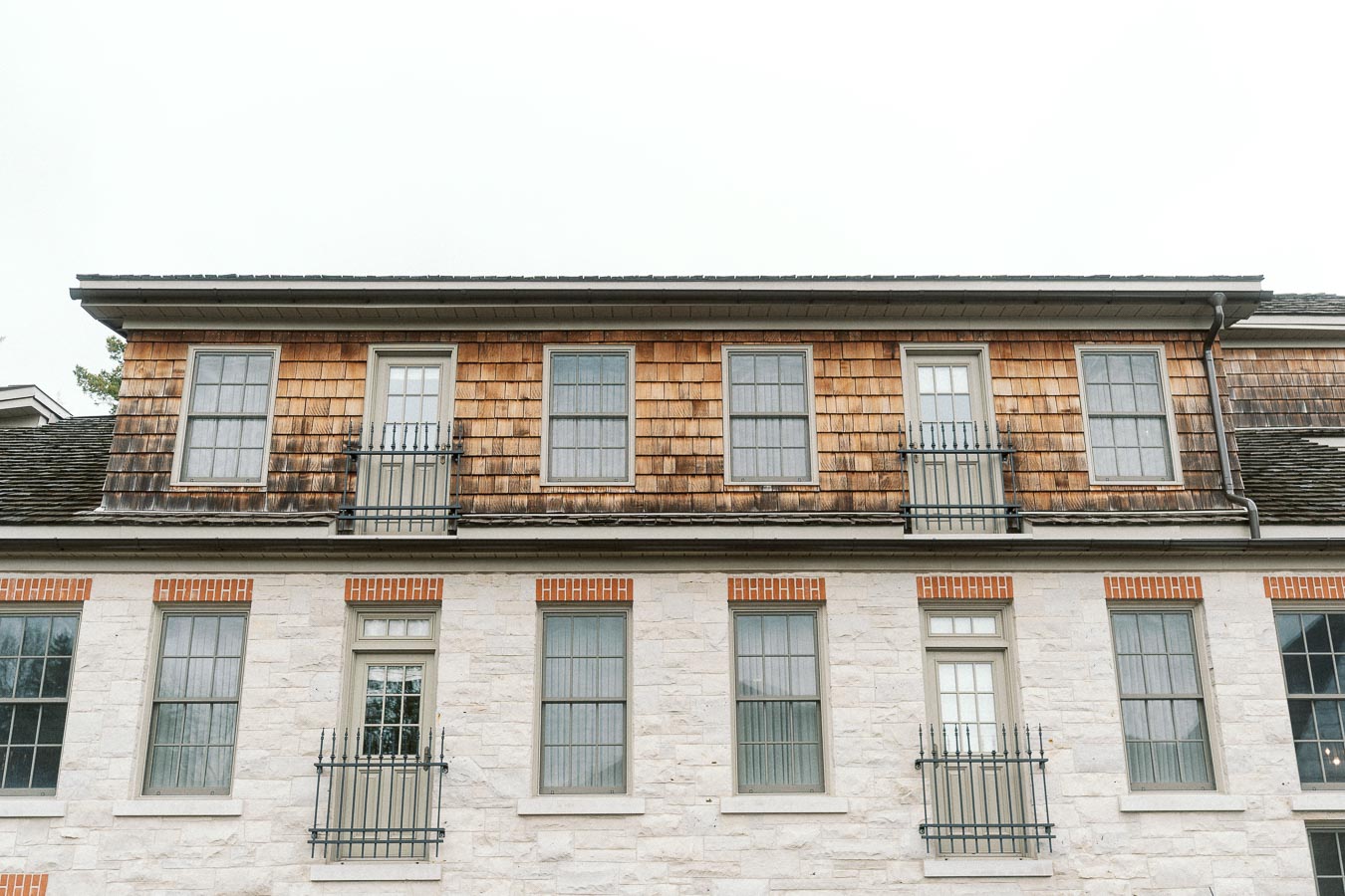 Historic stone and wood building facade with rows of tall windows