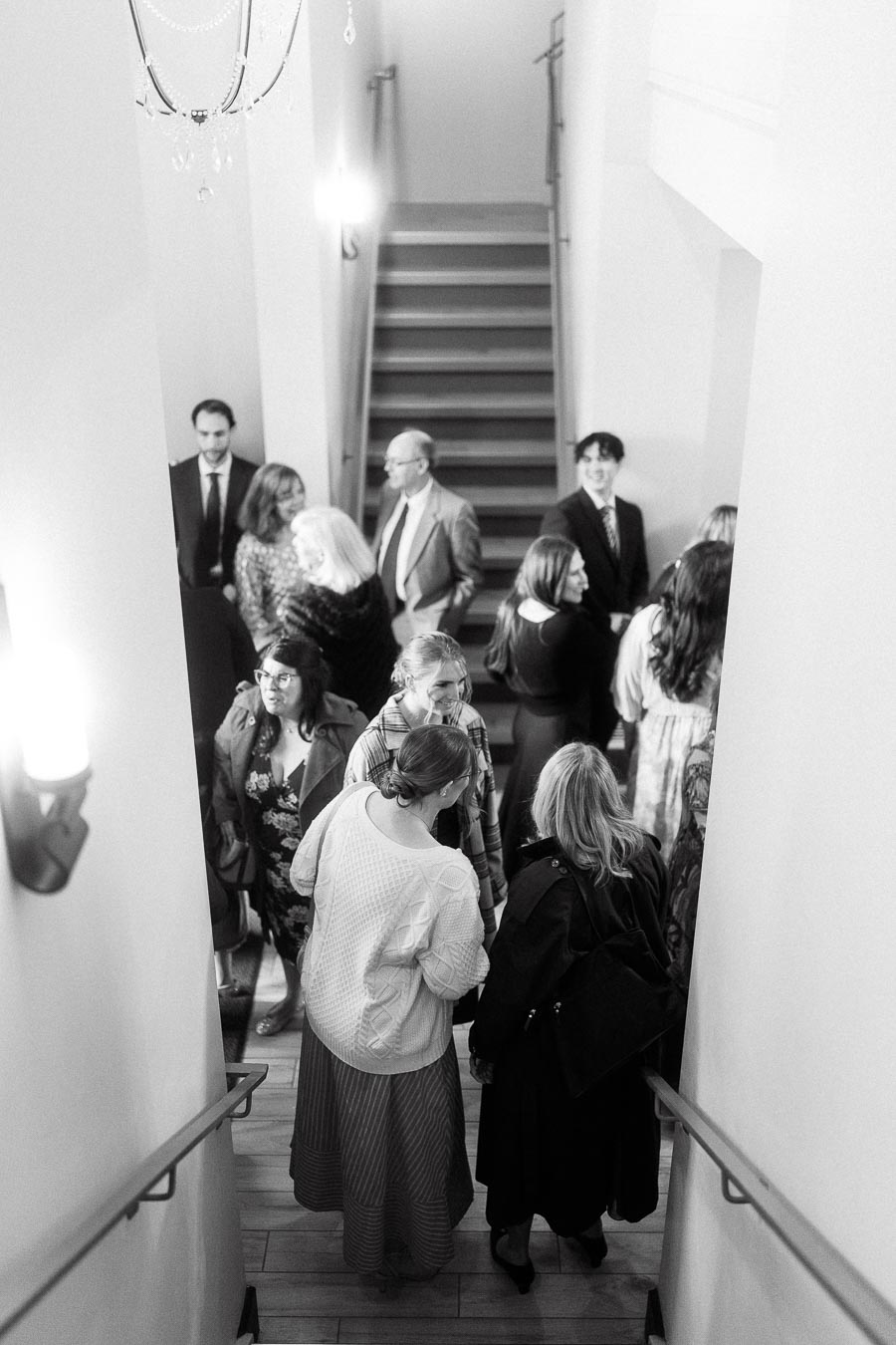 Guests mingling in a stairwell during an indoor engagement gathering