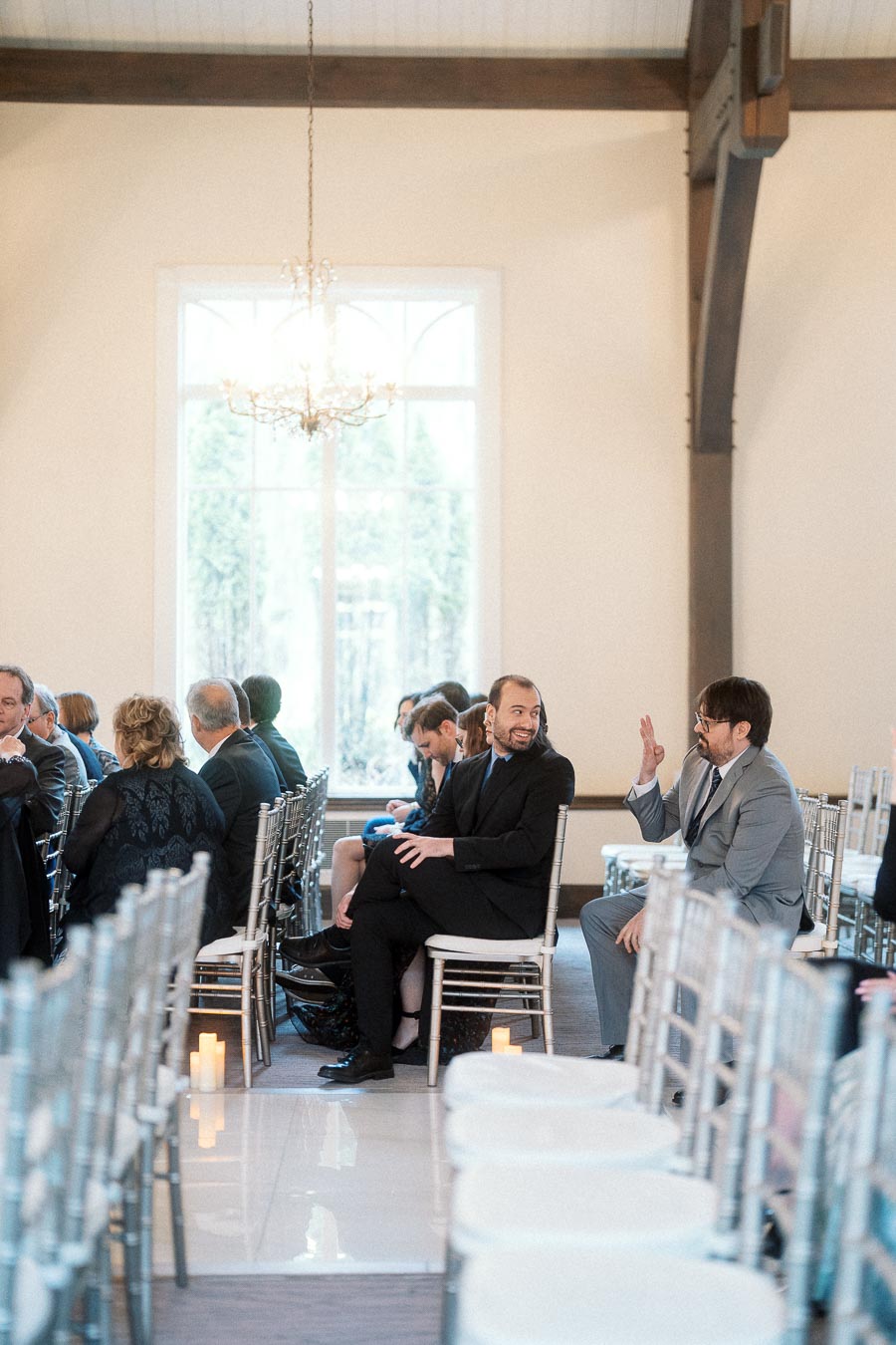 Guests seated in rows of chairs inside a bright ceremony space.