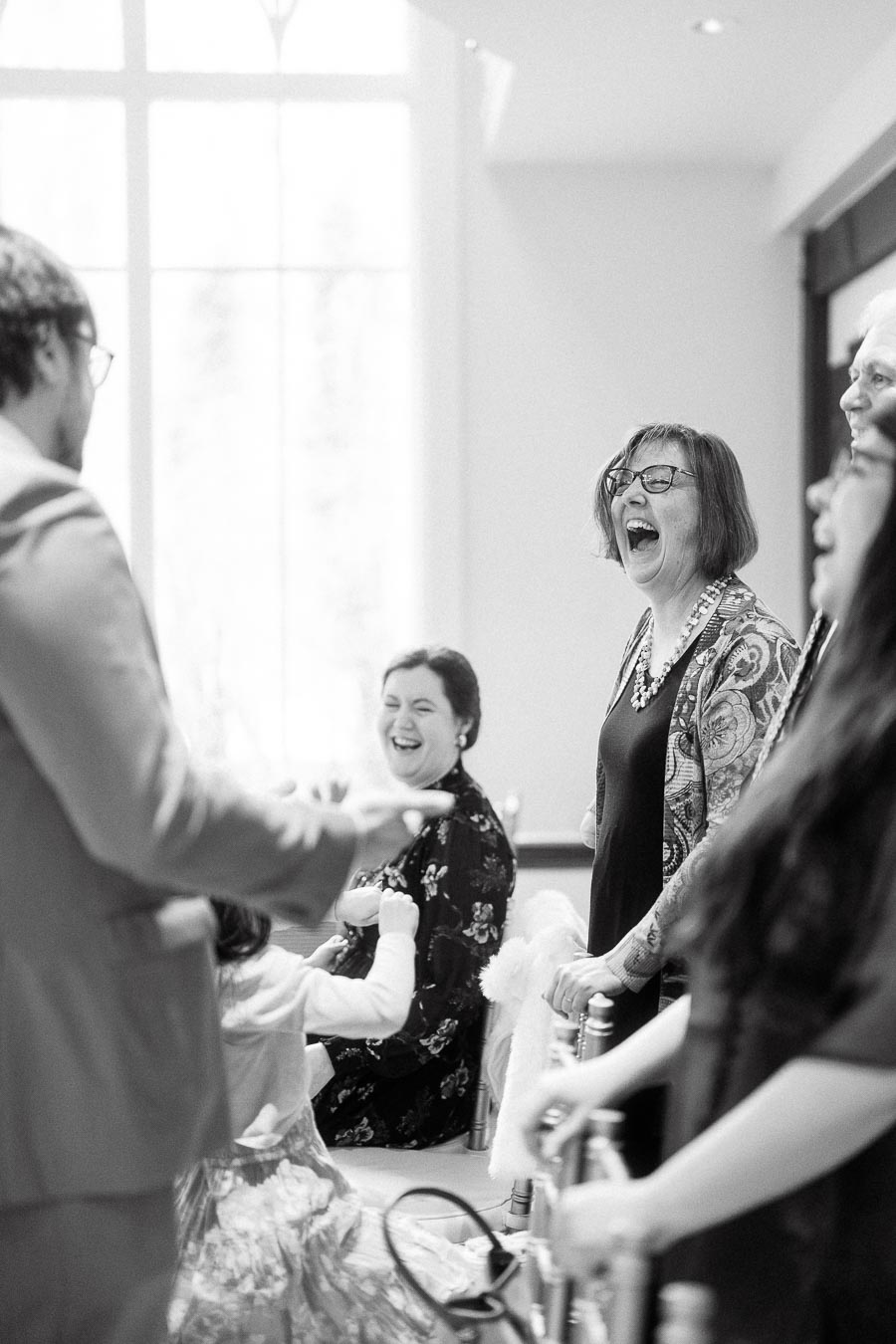 Guests laughing together indoors during a candid engagement photoshoot moment