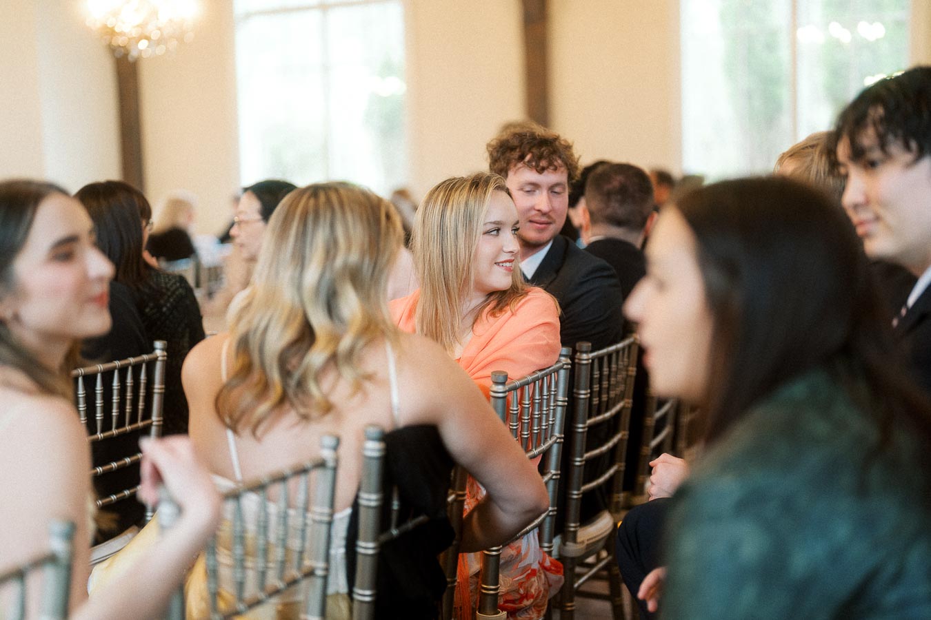 Guests seated in rows of chairs during an indoor engagement celebration