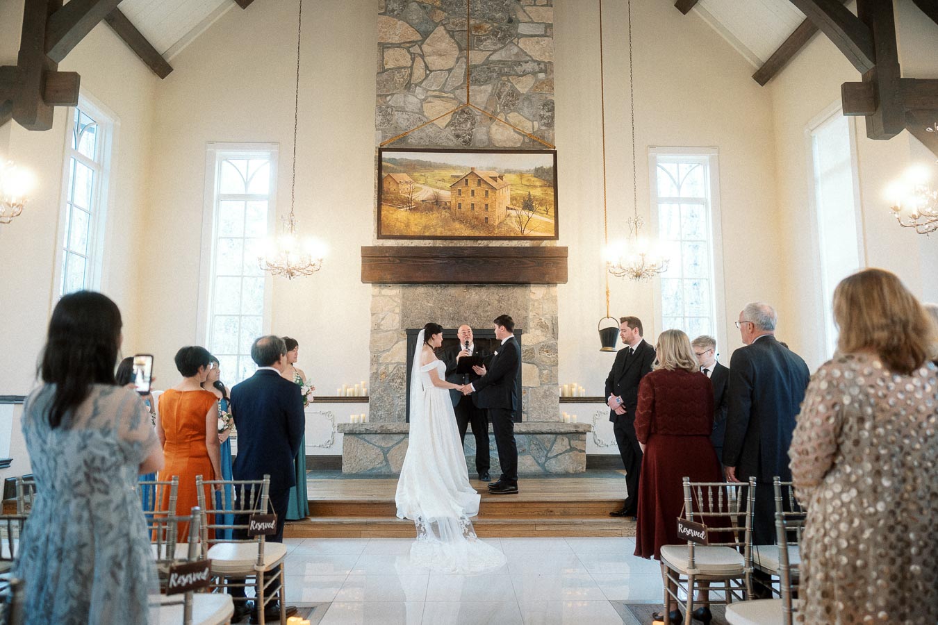 Couple standing at the altar during an indoor wedding ceremony with guests watching