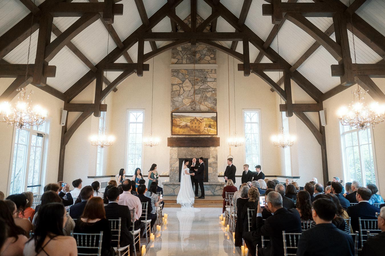 Couple exchanging vows during an indoor wedding ceremony with guests seated in a chapel-like hall