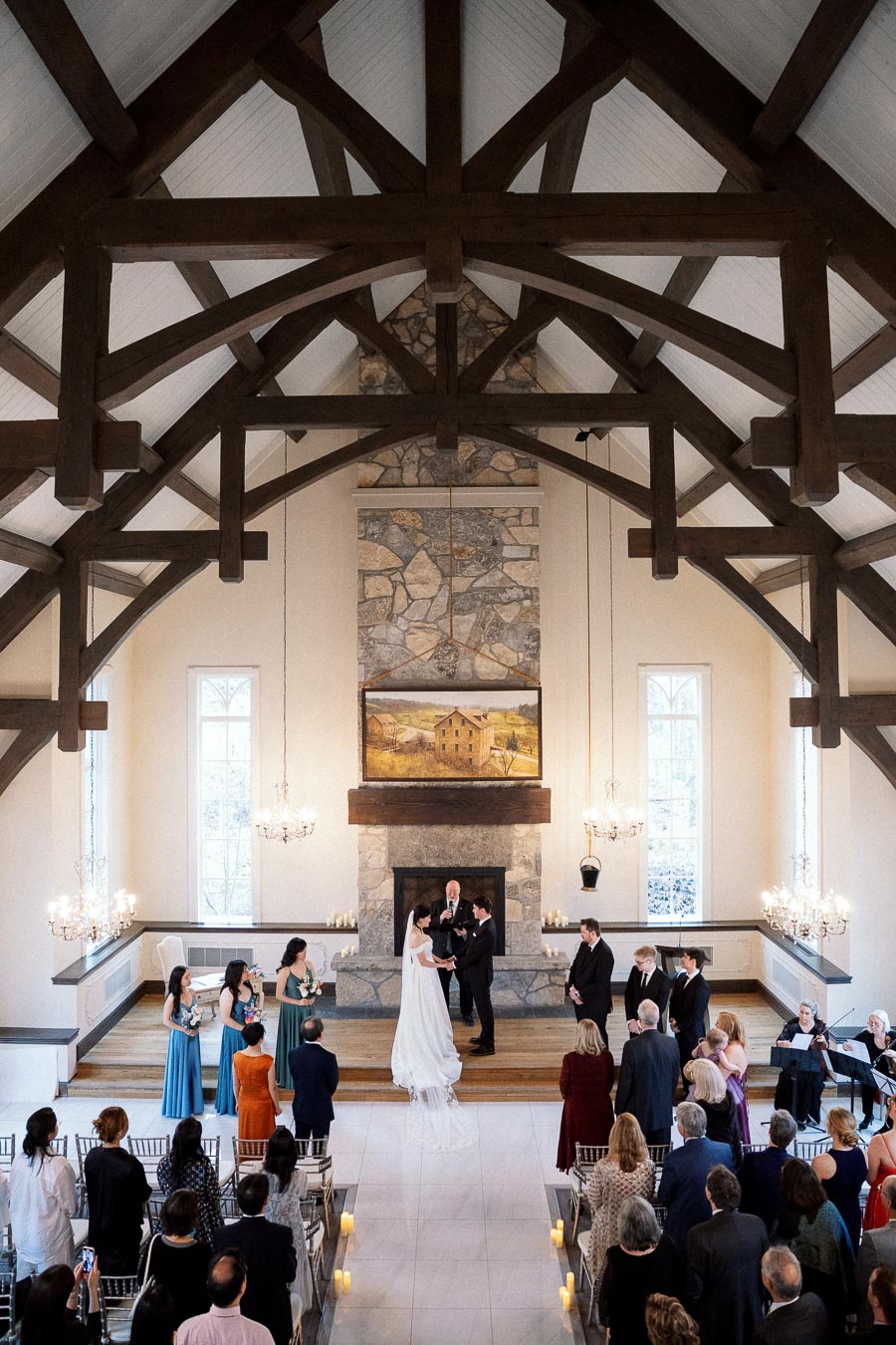 Couple exchanging vows during an indoor wedding ceremony beneath wooden beams