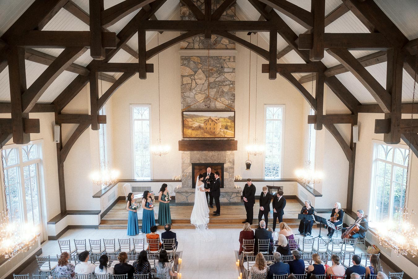 Couple exchanging vows in a timber-framed chapel with seated guests and musicians