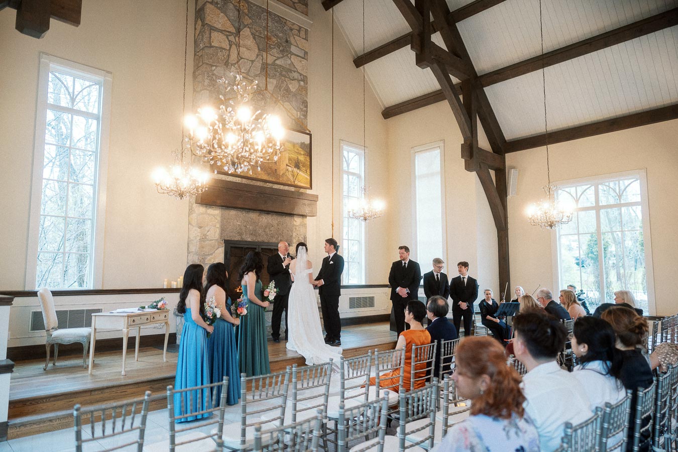 Couple exchanging vows during an indoor wedding ceremony with guests seated nearby