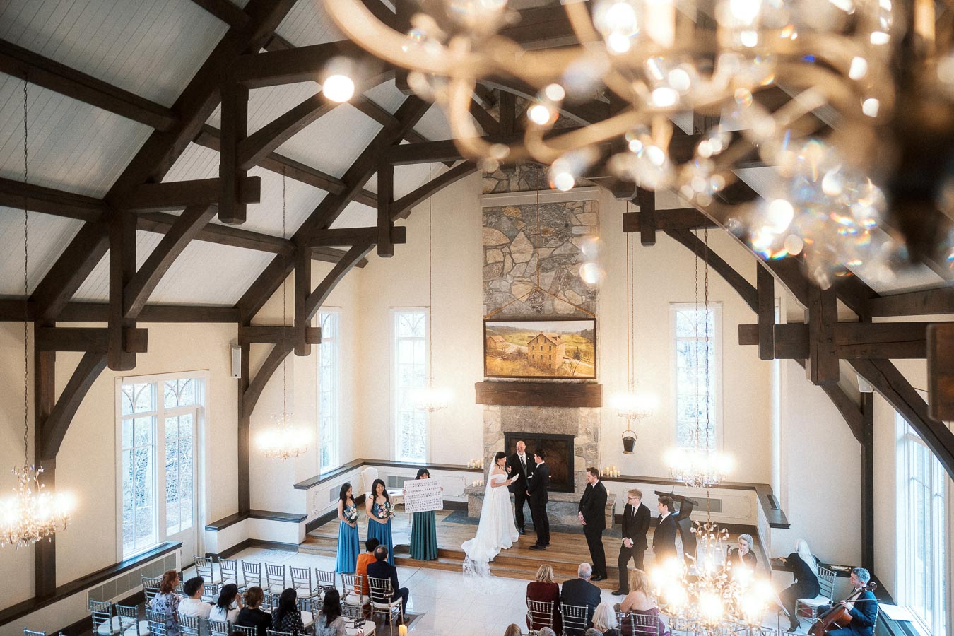 Couple exchanging vows during an indoor ceremony in a timber-framed hall.