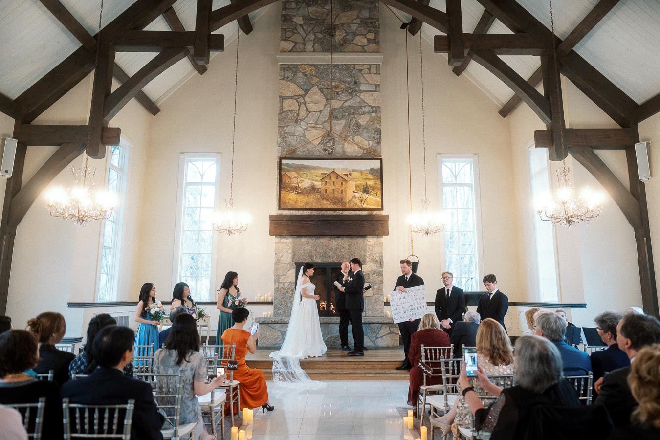 Couple exchanging vows during an indoor wedding ceremony with guests seated in rows.