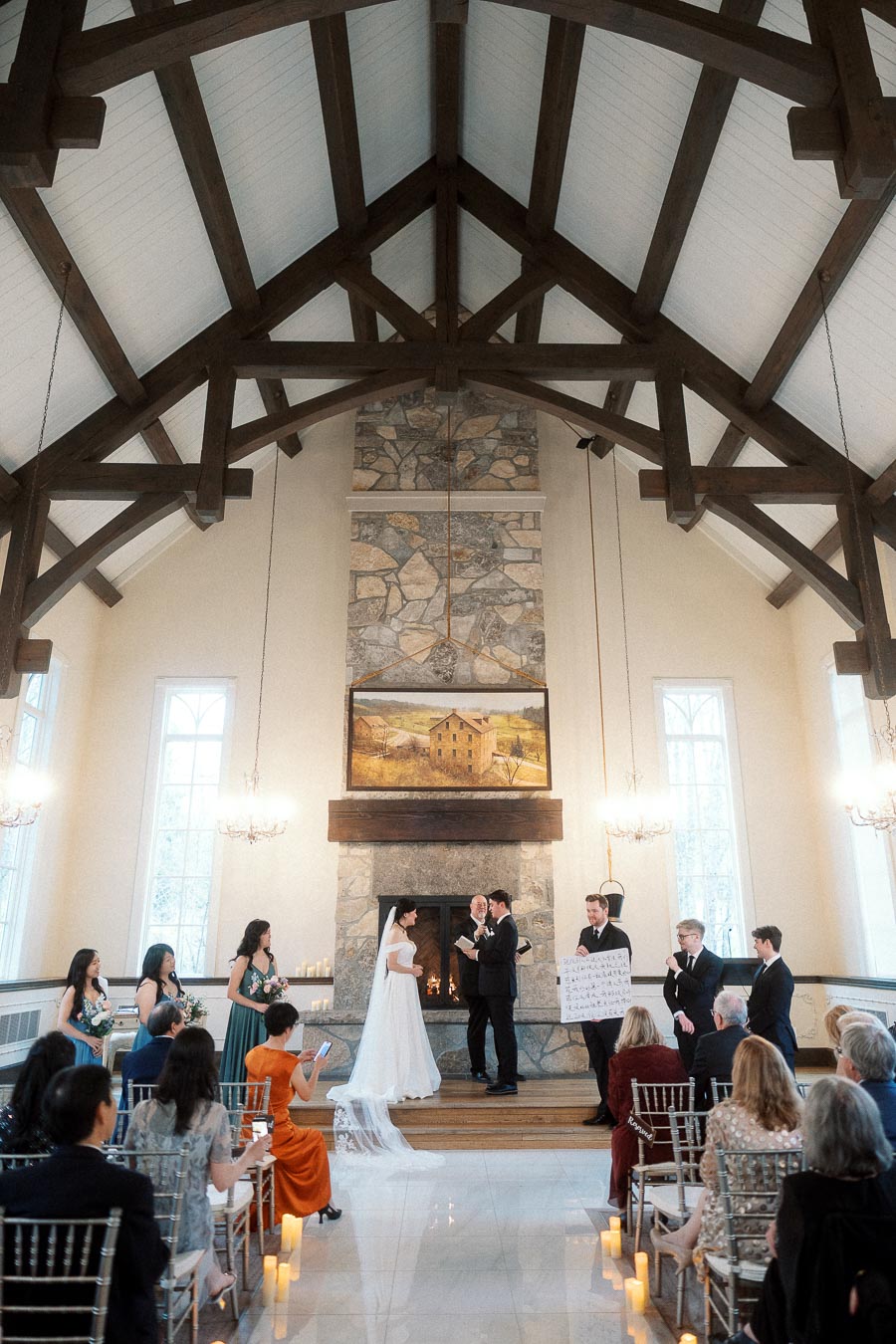 Couple exchanging vows during an indoor wedding ceremony in a timber-beamed chapel