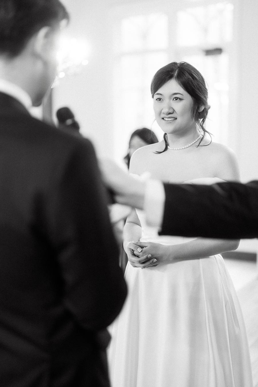Bride smiling at her partner during an indoor ceremony