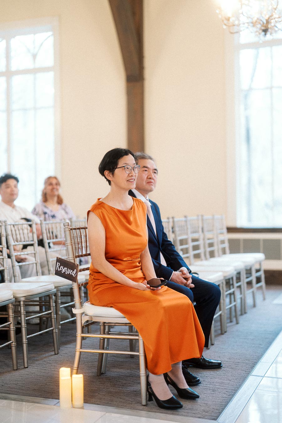 Guests seated in reserved chairs inside a bright ceremony room