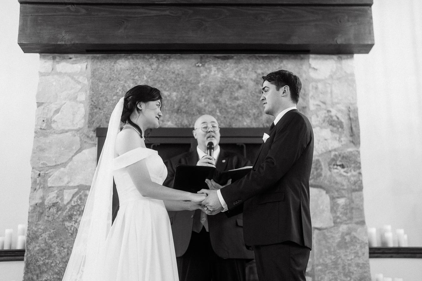 Bride and groom holding hands during a wedding ceremony before an officiant.