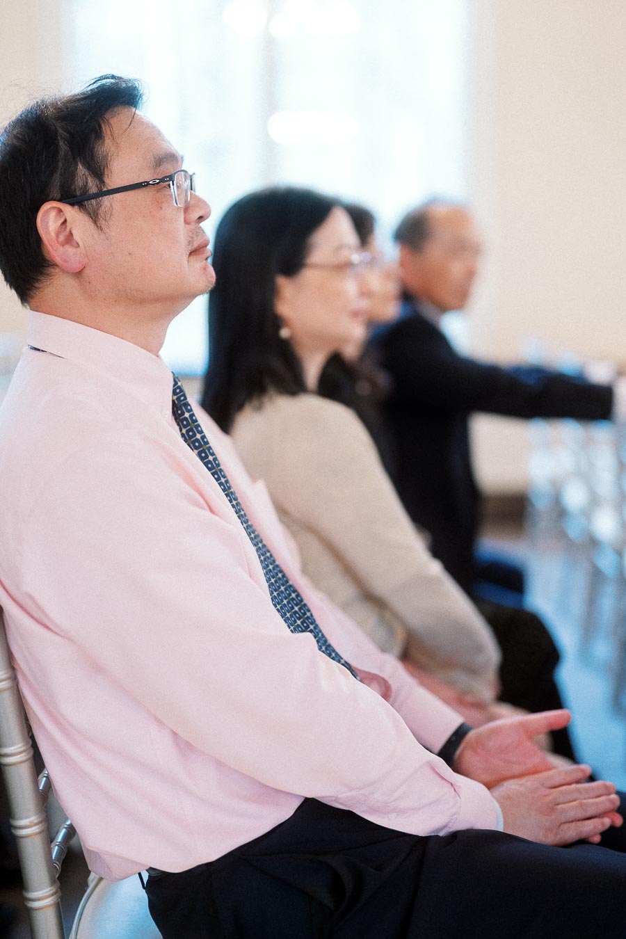 Guests seated in a row indoors during an engagement event