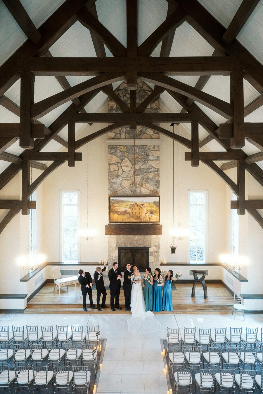 Wedding party standing at the altar inside a timber-framed ceremony hall.