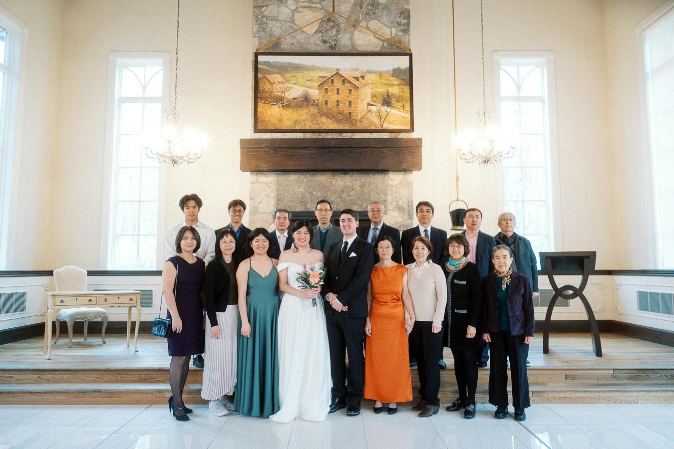 Formal group portrait with a couple and family inside an elegant room with a fireplace