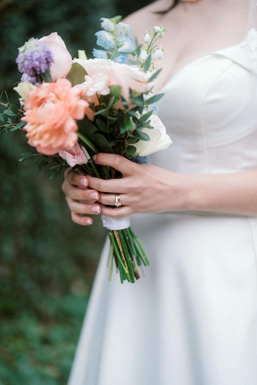 Bride holding a pastel bouquet with an engagement ring visible
