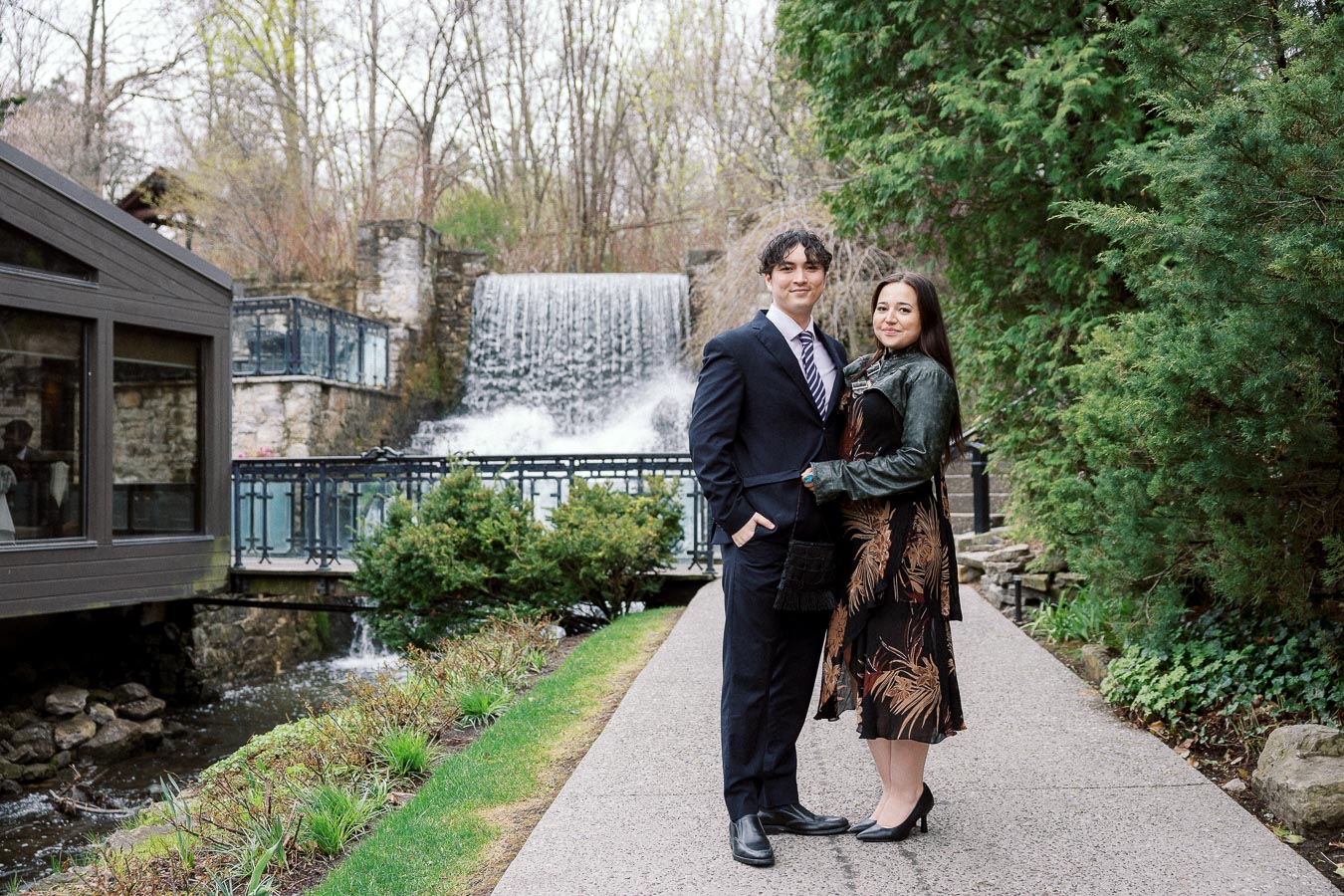 Couple posing on a garden path with a waterfall behind them