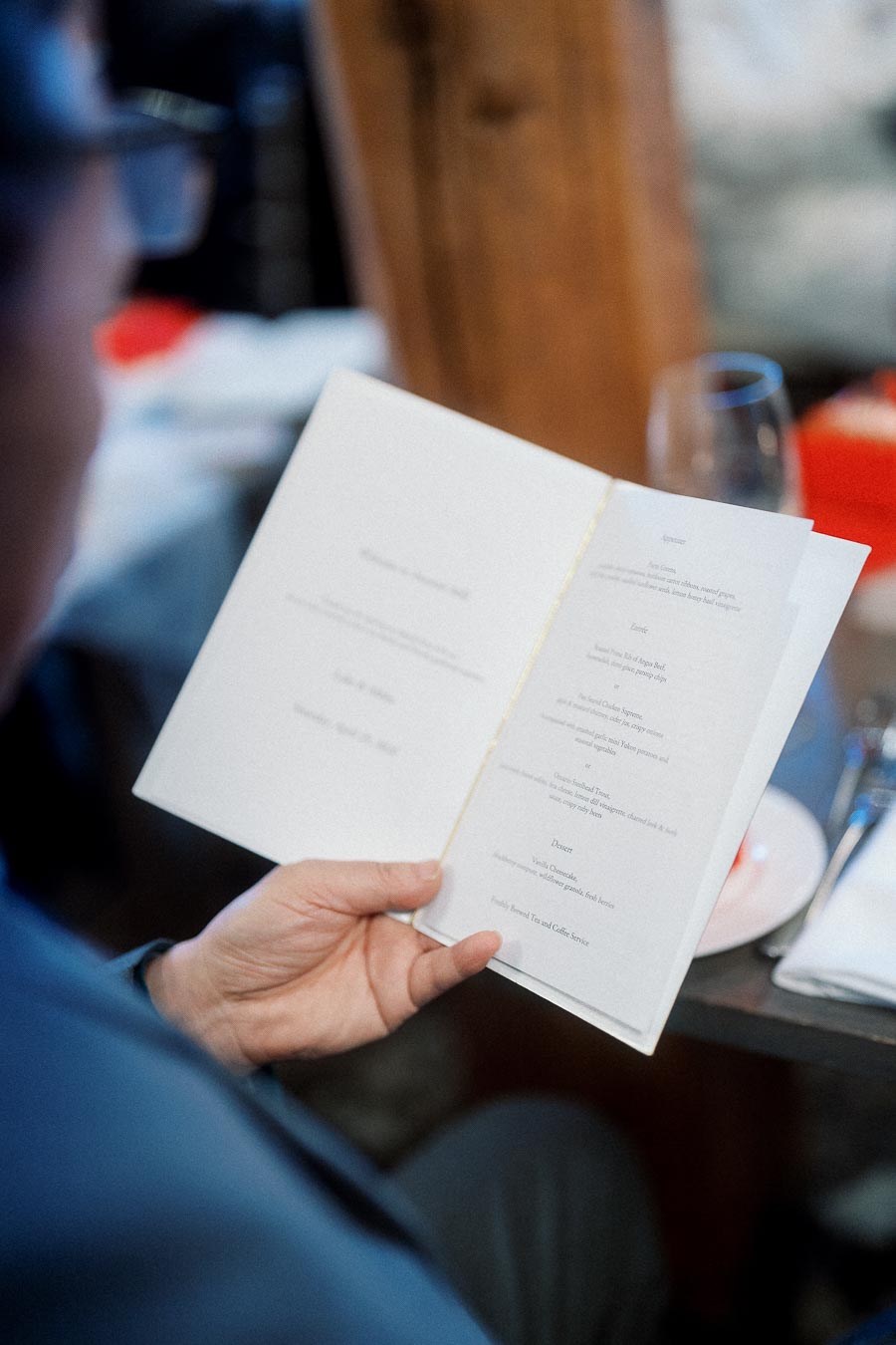 Person holding an open menu at a restaurant table