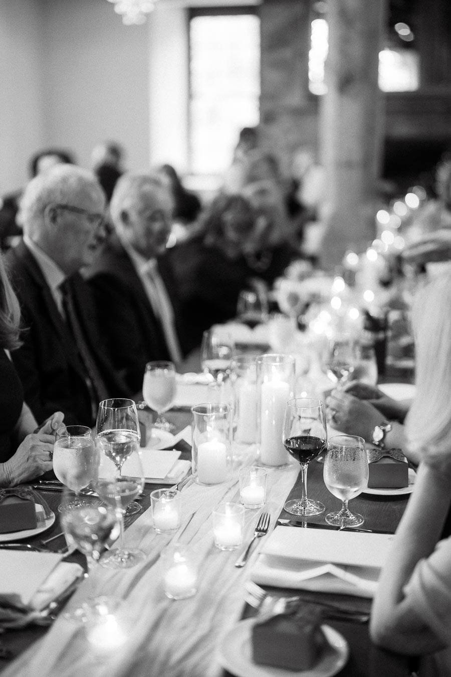 Guests seated at a candlelit dinner table during an intimate reception