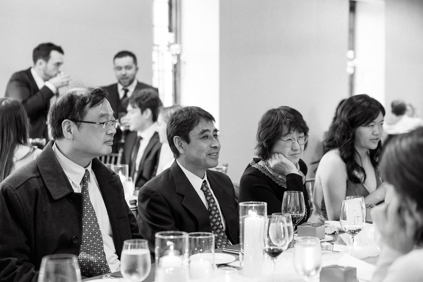 Guests seated at a candlelit reception table during a formal event